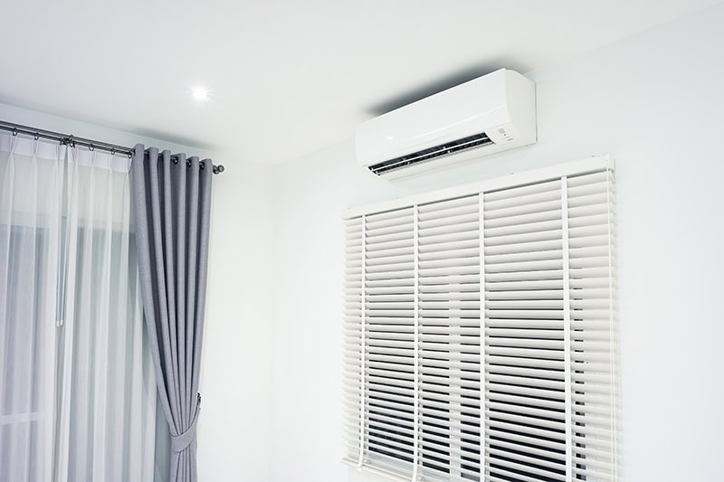 Air conditioner (ac) wall mount or indoor unit. Include Adjusting vertical or venetian blinds, eyelet curtains both blackout and translucent. Air conditioner is part of air conditioning HVAC split system consist of electric fan, filter and evaporator coil for climate, temperature and humidity control. To cool or cold in room of home or house building at night.