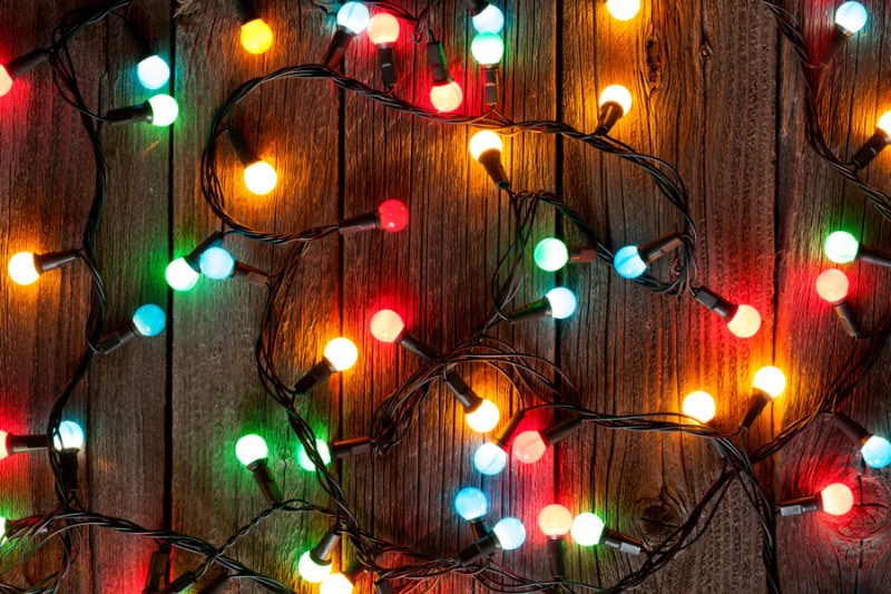 Holiday Safety Tips in Leland. Christmas colorful lights on wooden table.