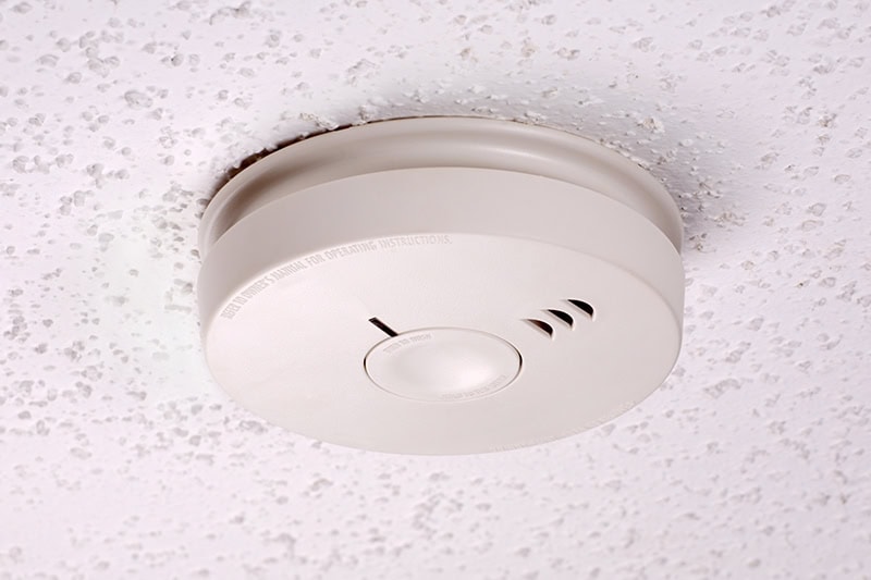 An image of a smoke detector installed on a ceiling.
