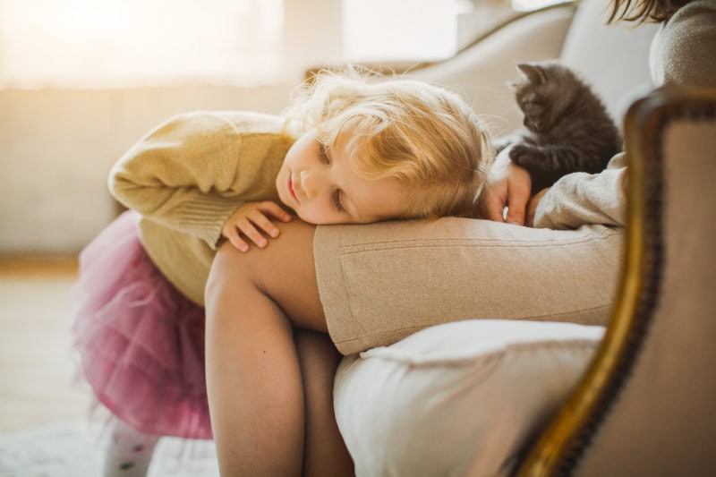 The Basics of Winter Indoor Air Quality. A little girl laying on her mothers lap.