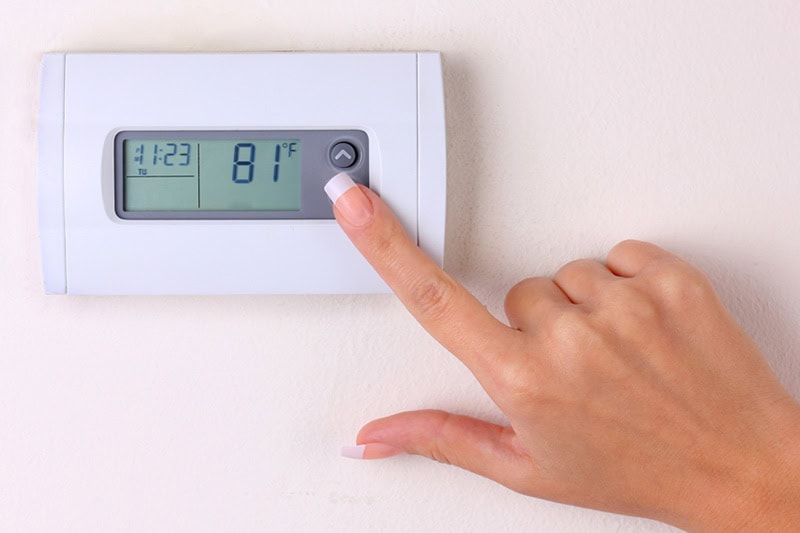 A finger on a Thermostat.