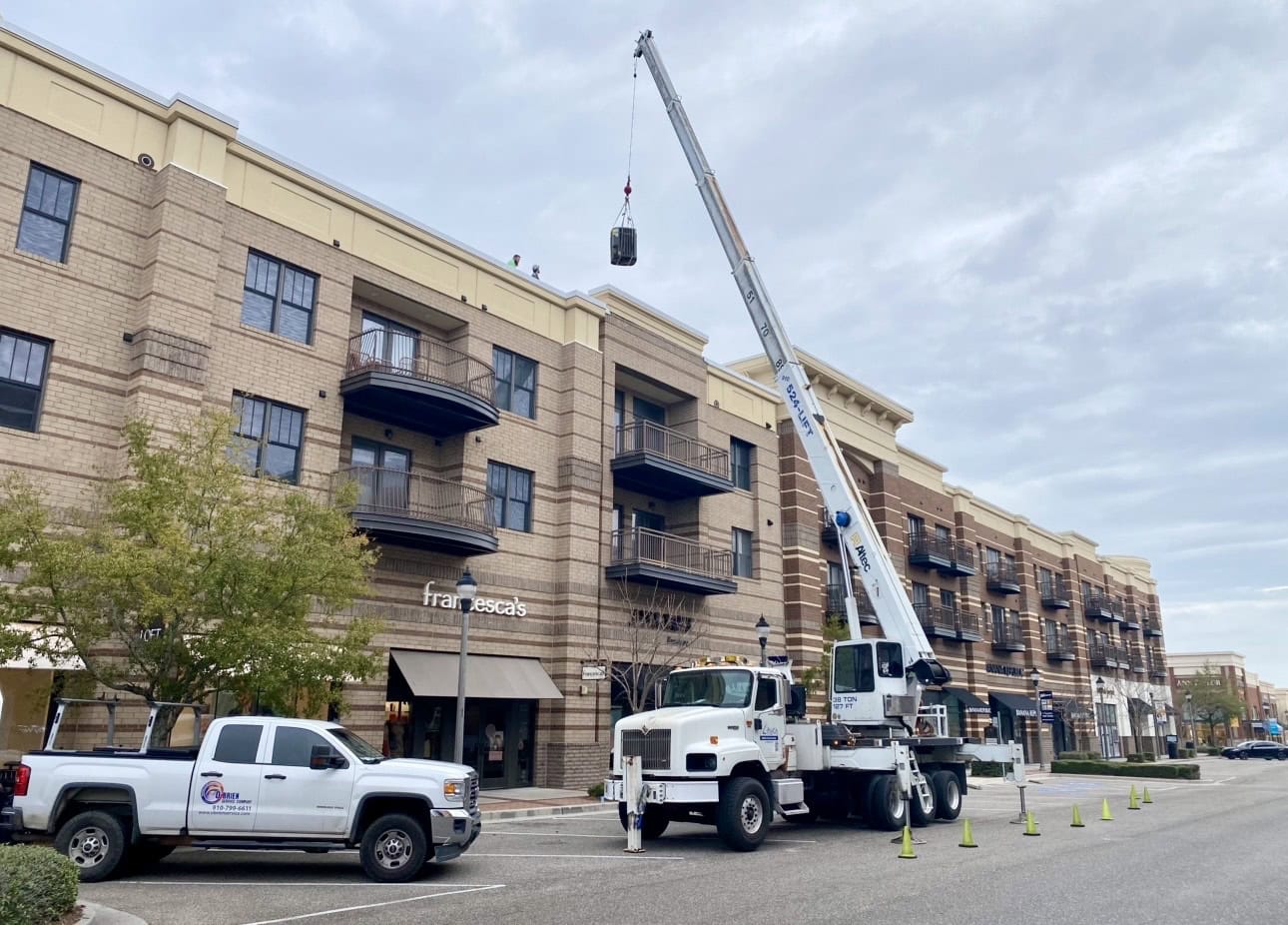 O'Brien Service Company Replacing an AC unit on a commercial building using a crane.